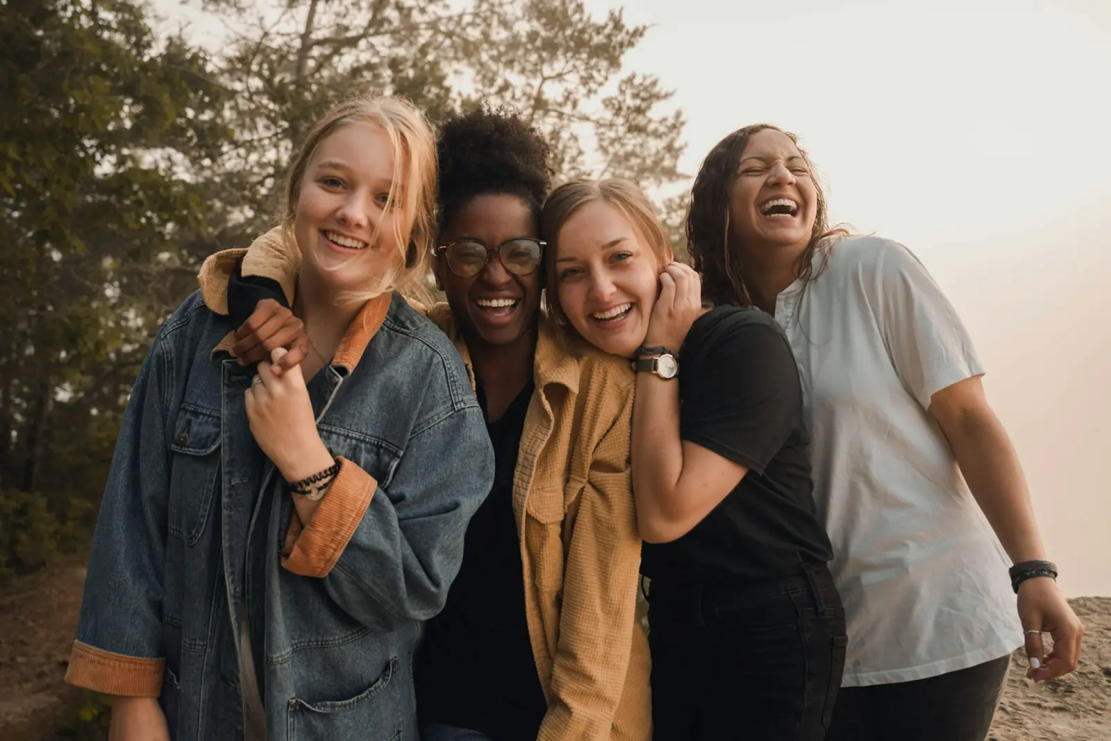 Four friends laughing together outdoors
